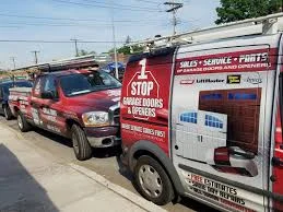 Two 1 Stop Garage Doors & Openers service vehicles parked on a Long Island street